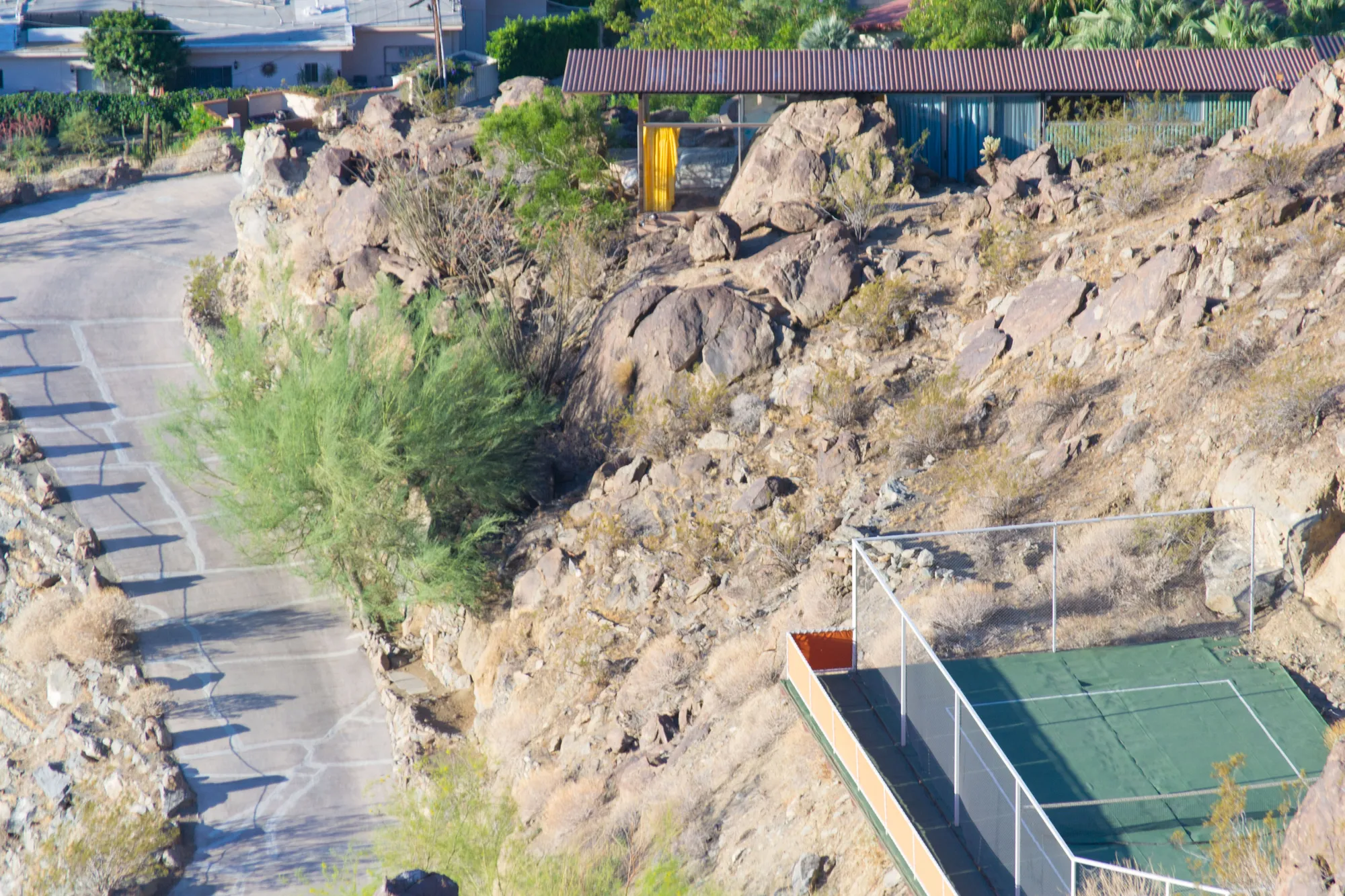 Frey House II small on a rocky hillside above Palm Springs, seen from a trail.