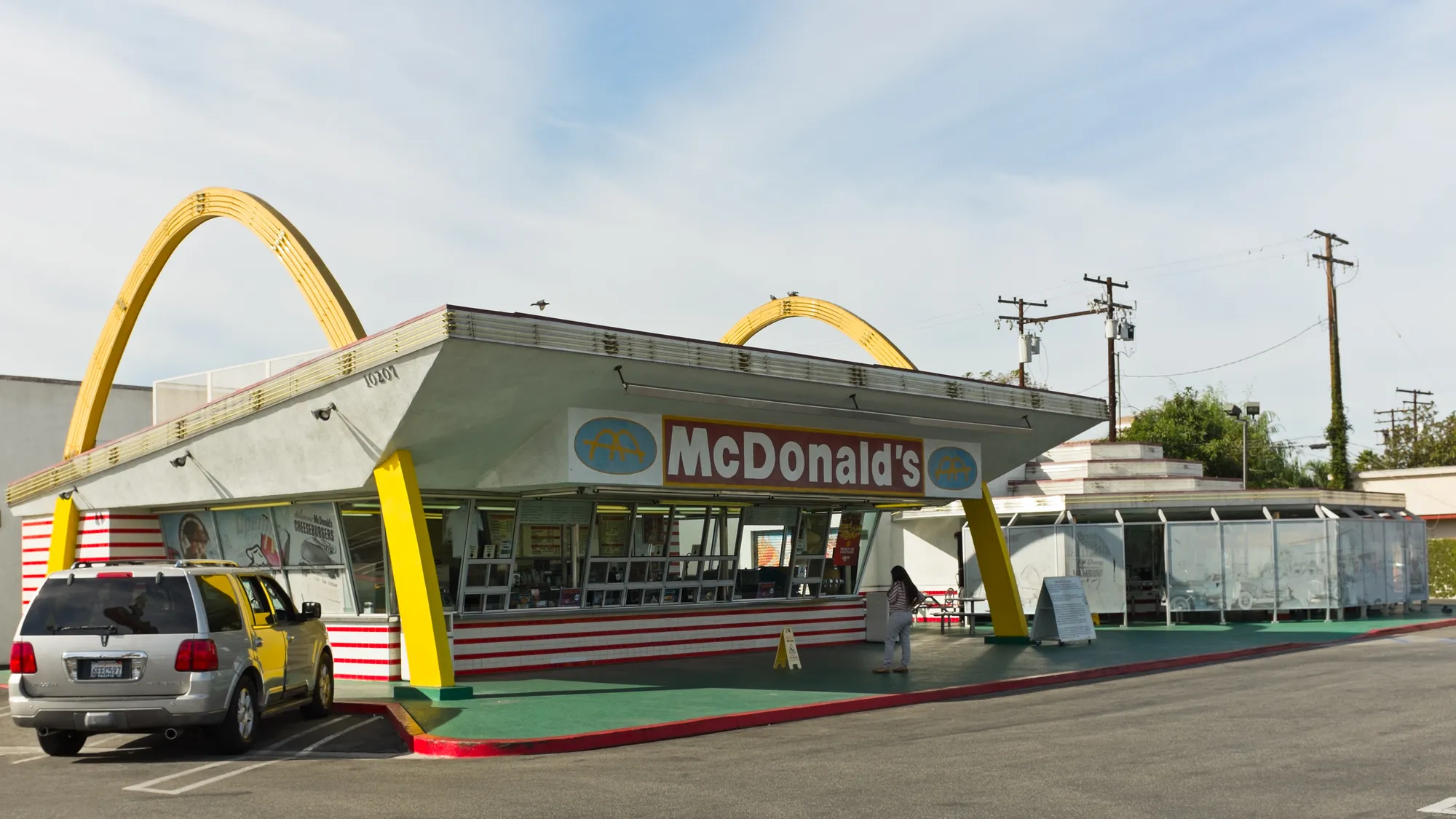 The Downey McDonald’s with its yellow arches rising through a slanted roof, and the museum building beside it.