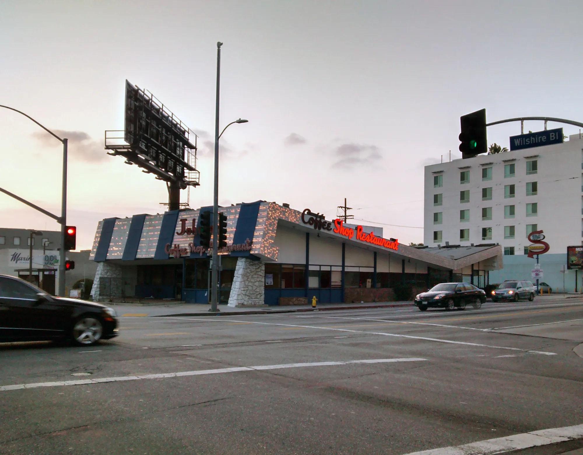 Johnie’s Coffee Shop on the corner of Wilshire Boulevard and Fairfax Avenue, with its angled roof and tall sign.