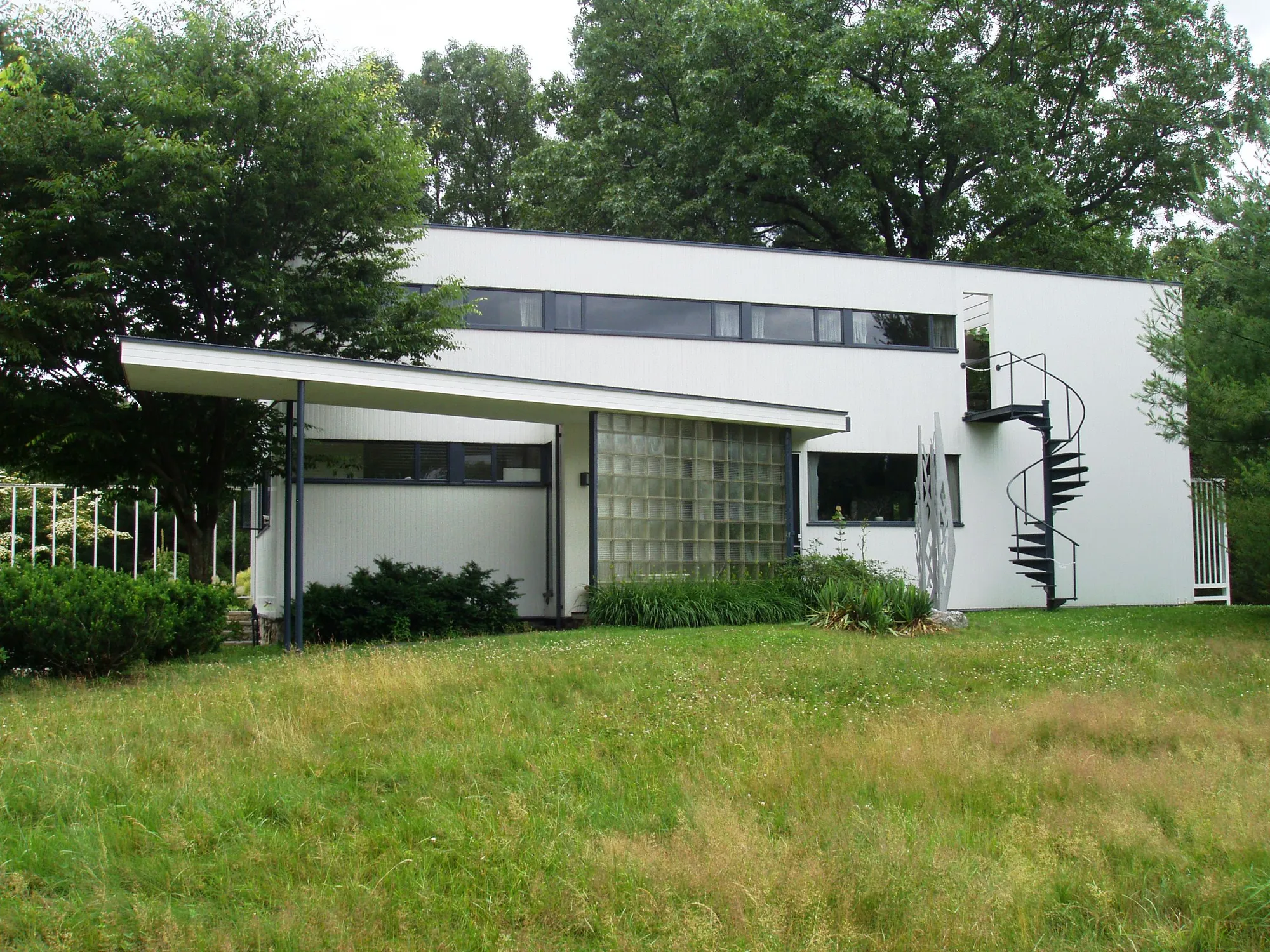 The front of Gropius House, a white house with a glass block wall at the entrance.