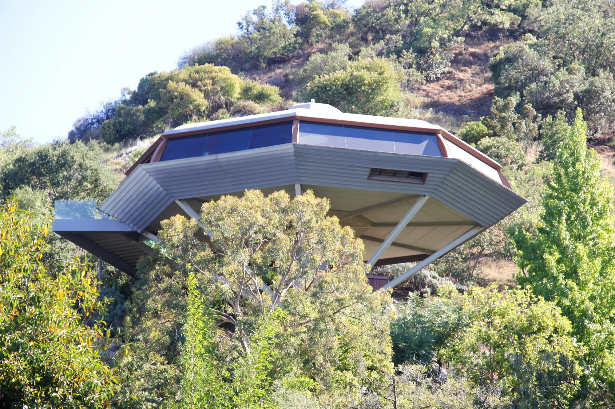 Close view of the octagonal Chemosphere house and its structure on the hillside.