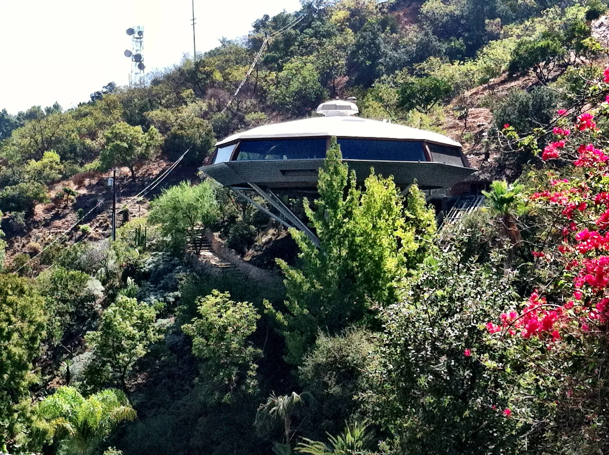 The Chemosphere, an octagonal house on a tall column, on its wooded hillside.