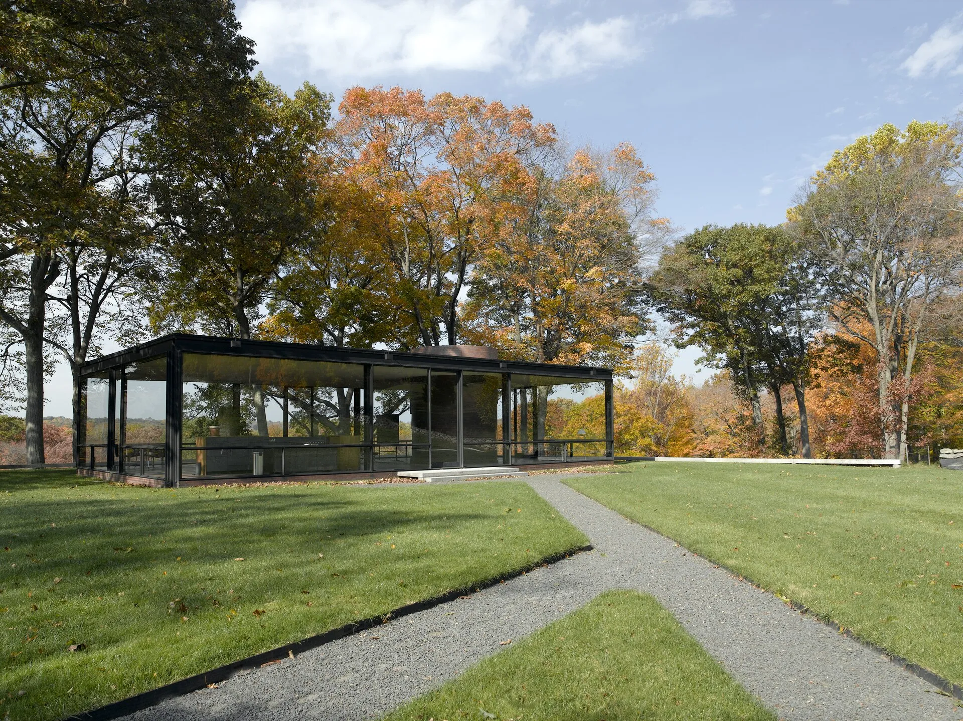 The Glass House in New Canaan among autumn foliage.